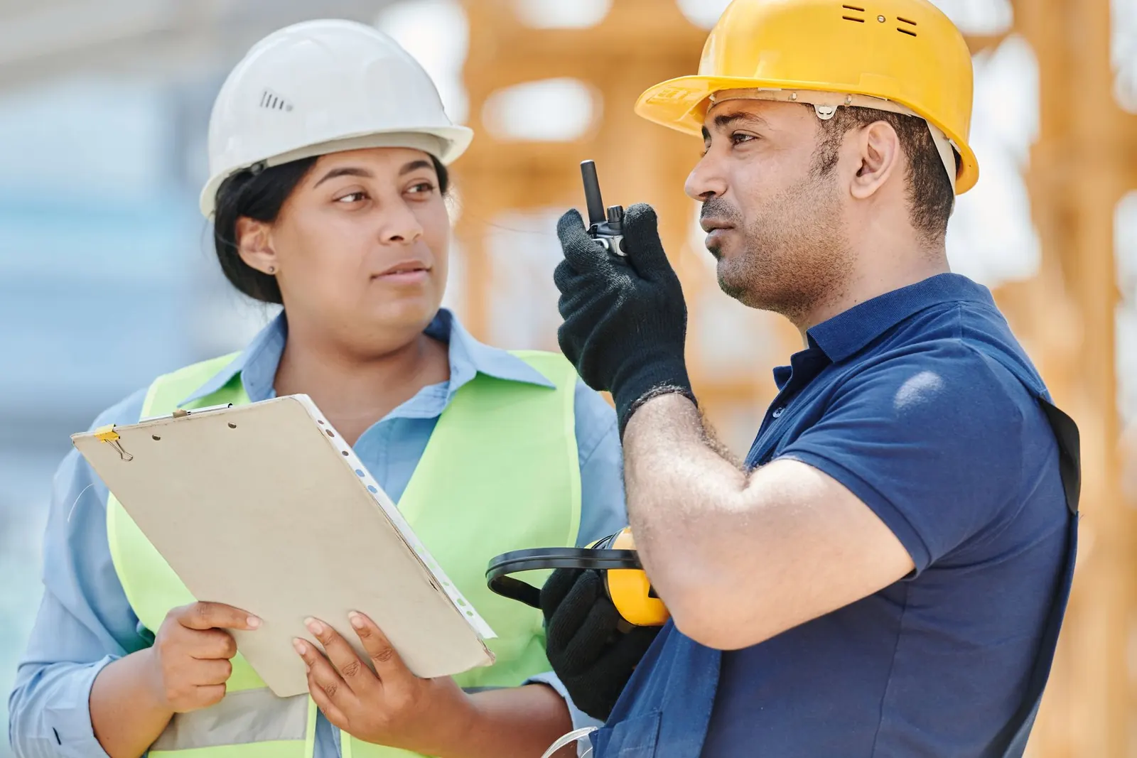 Construction workers wearing hard hats and safety vests at a jobsite