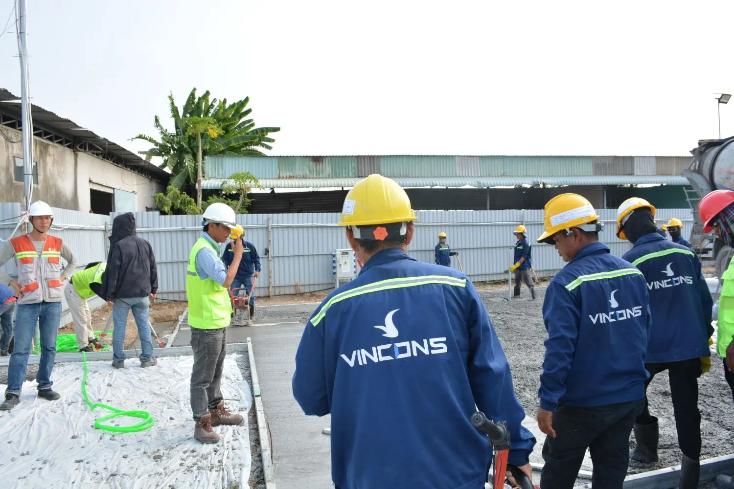 Construction workers with hard hats assessing an outdoor worksite